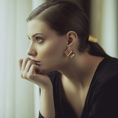 Side face of women in black dress wearing Obnoxious Cube Sterling Silver Gold Plated Earrings