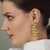 Side face of Women wearing Golden tiles women earrings made using sterling silver gold plated