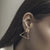 Woman's Ear wearing Traingular Gate Sterling Silver Gold Polished Earrings