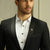 Man in Black Suit White shirt wearing Gold Polished The Quoin Lapel Pins for Men's Formal Wear